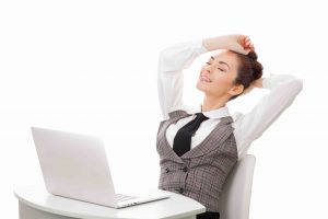 Young attractive woman at modern office desk, with laptop, stretching, getting a little exercise during the day, completing difficult task time for lunch. Businesswoman against white isolated background. Business concept illustration.