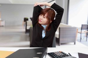 Businesswoman stretching herself or exercise while working at office - office syndrome concept